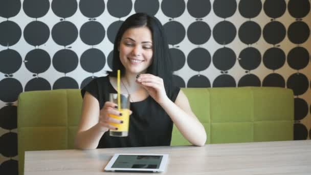 Красивая девушка пьет апельсиновый сок в помещении — стоковое видео