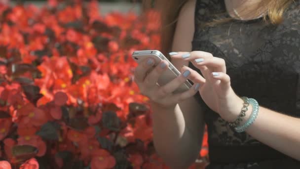 Menina segurando um smartphone no parque ao ar livre — Vídeo de Stock