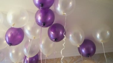 Tavanda yüzen beyaz ve mor balon