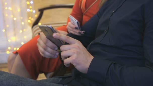 Девушка и мужчина просматривают фотографии со своих смартфонов — стоковое видео