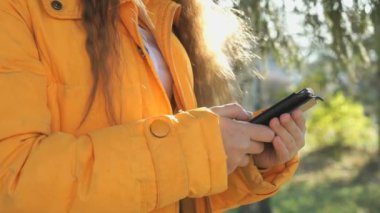 Bir cep telefonu kullanarak onun fotoğrafları ile ilgilenen kız