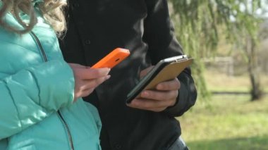 Genç çift stand ve cep telefonları tutun