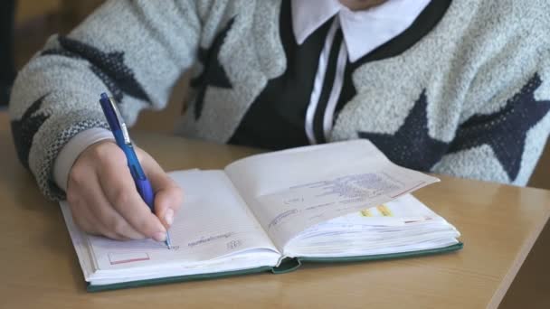 Estudante escreve o texto no caderno dentro de casa — Vídeo de Stock