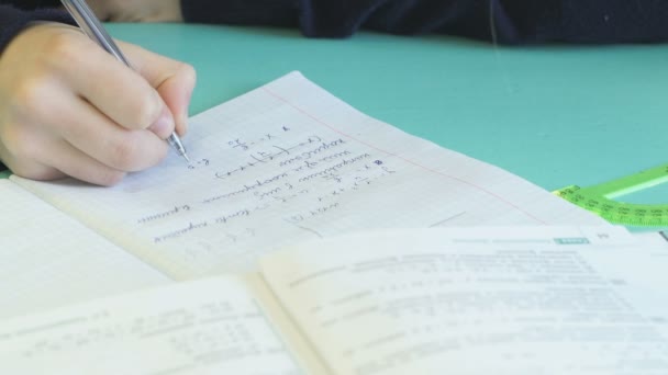 El alumno decide la tarea del hogar en un cuaderno — Vídeo de stock