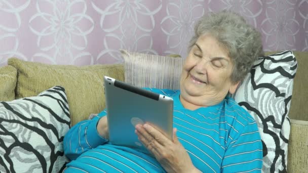 老女人抱着一台平板电脑在室内 — 图库视频影像