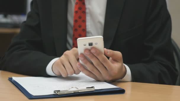 Homem sentado escrevendo o texto usando o smartphone — Vídeo de Stock