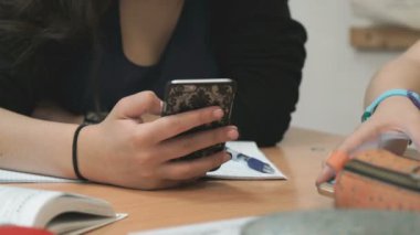 Bir cep telefonu kullanarak fotoğraflarına bakmaktan kız öğrenci