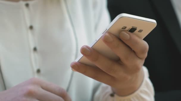 Meisje bekijkt de foto's met behulp van de witte mobiele telefoon — Stockvideo