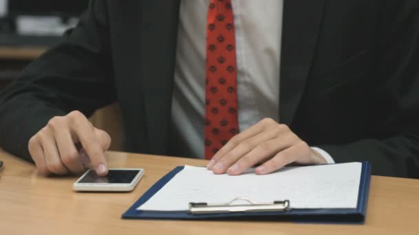 Man op zoek naar de foto's met behulp van mobiele telefoon binnenshuis — Stockvideo