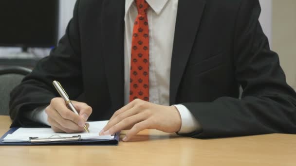 Estudiante sentado en el escritorio dentro — Vídeos de Stock