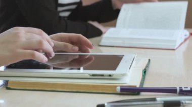 Öğrenci bilgisayar tablet kullanarak metni okur