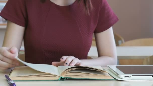 Ragazza legge il libro di testo della scuola a scuola — Video Stock