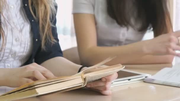 Chica hablando entre sí y volteando los libros de texto — Vídeos de Stock