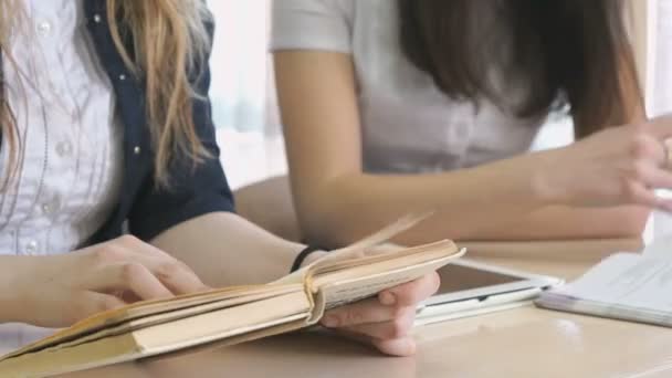 Girl talking each other and flipping the textbooks — Stock Video