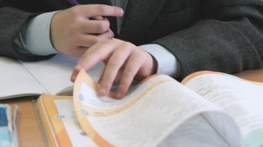 Öğrenci ders kitabı sayfa okulda çevirir.