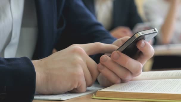 Boy escribe el texto usando un teléfono móvil en el interior — Vídeos de Stock