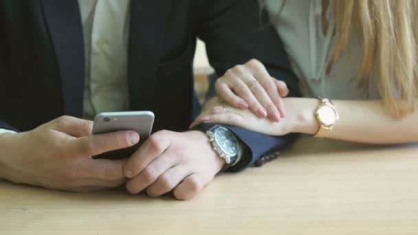 Guy y chica viendo fotos usando un teléfono móvil — Vídeo de stock