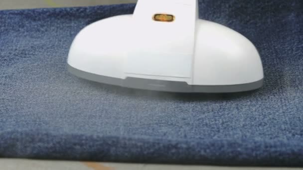 Woman steaming denim fabric on ironing table — Stock Video