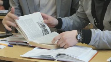 İki genç ders kitaplarının sayfaları çevir