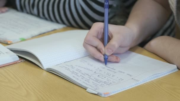 Schüler schreibt mit Stift Text in Schulheft — Stockvideo