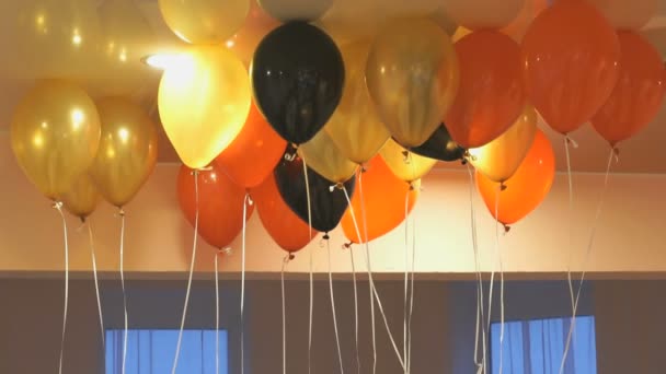 Bunte Luftballons schweben drinnen an der Decke — Stockvideo