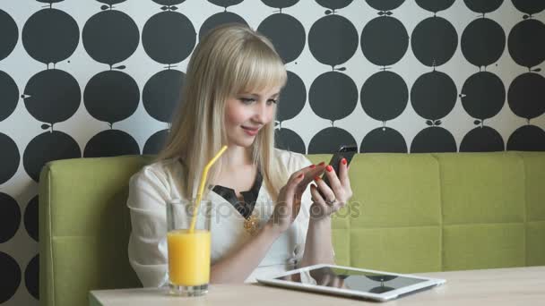 年轻女孩在咖啡馆喝橙汁 — 图库视频影像