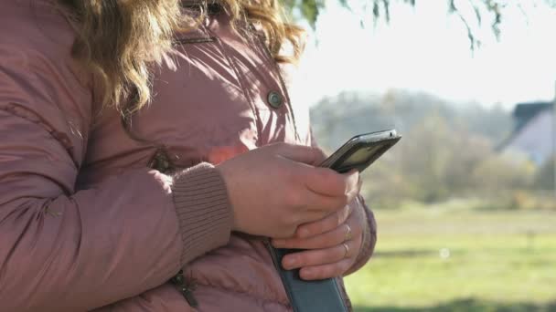 Den attraktiva flicka som håller en mobiltelefon — Stockvideo