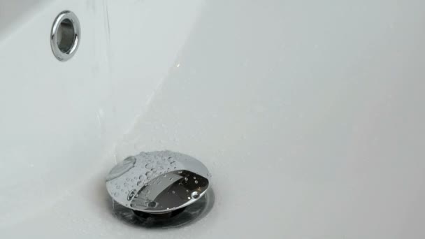 Процесс слива воды в белую раковину — стоковое видео