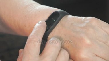 Yaşlı kadın bileklik fitness İzleyicisi'ni kullanma