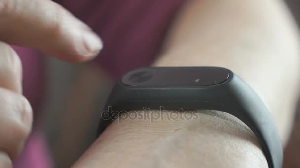 La vieille femme utilisant le bracelet de fitness tracker 