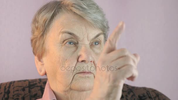 高齢女性は顔の前で人差し指を波します。 — ストック動画