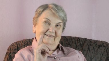 Yaşlı kadın onun parmağı yüz önünde dalgalar
