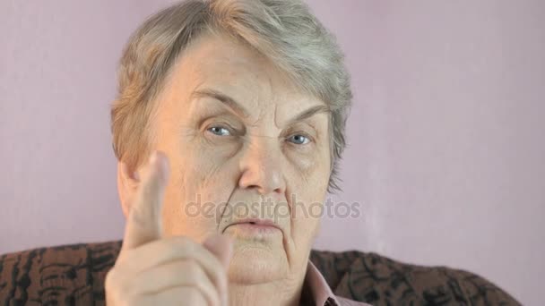 Старушка машет указательным пальцем перед лицом — стоковое видео