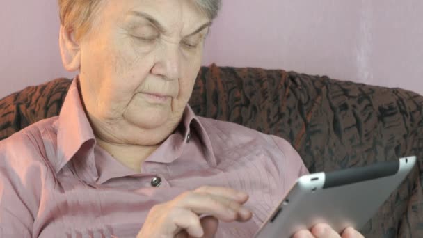 Mujer mayor con tableta digital en el interior — Vídeos de Stock