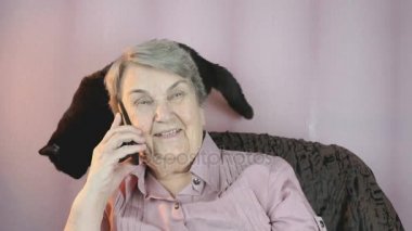 Yaşlı kadın 80s kara kedi yanında oturan