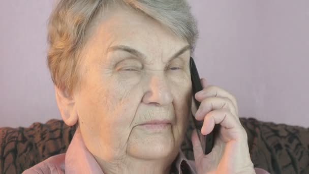 Idős nő komolyan beszél a mozgatható smartphone — Stock videók