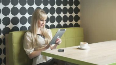 Kız bir bilgisayar tablet kullanarak fotoğraflara görünüyor