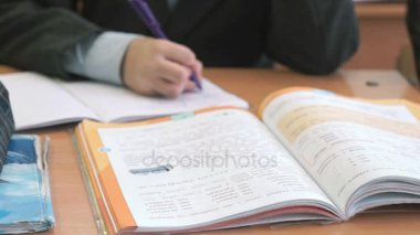 Okulda ev görev yaparken masada oturan çocuk