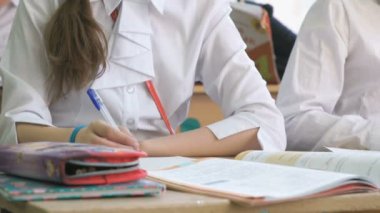 Öğrenci ext topu kalem kullanarak bir defterini yazıyor.