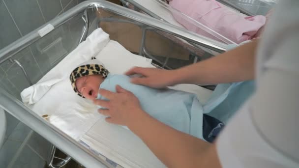 Νοσοκόμα φορέματα μέχρι ένα νεογέννητο σε ένα θάλαμο νοσοκομείου — Αρχείο Βίντεο