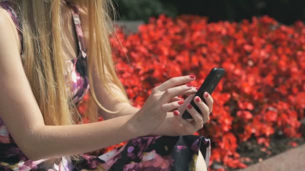 Menina segura um telefone celular e lê mensagens — Vídeo de Stock