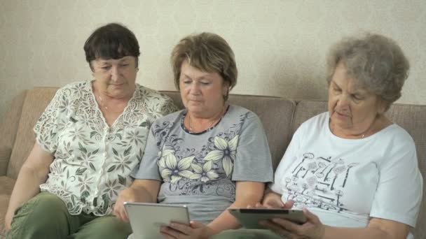 Las mujeres mayores miran fotos usando tabletas digitales — Vídeo de stock