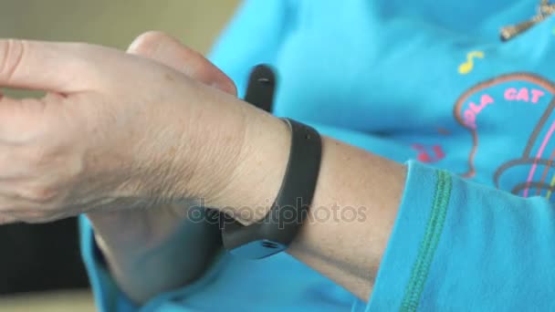 Woman dressing fitness tracker on arm. Close up — Stock Video
