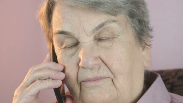 Пожилая женщина серьезно разговаривает на мобильном смартфоне — стоковое видео
