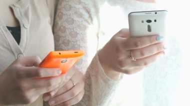 İki kız cep telefonunu kullanarak fotoğraf görüntüleme