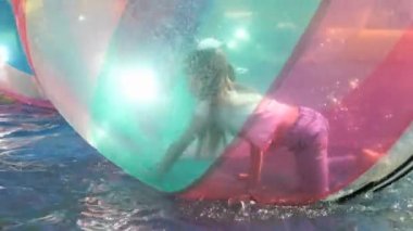 Küçük kızın büyük bir şişme top su içinde