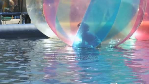 Kleiner Junge in einem großen aufblasbaren Ball im Wasser — Stockvideo