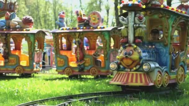 Los niños viajan en el pequeño tren eléctrico en el parque — Vídeos de Stock