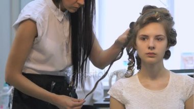 Profesyonel kuaför saç modeli bir kız için yapar.