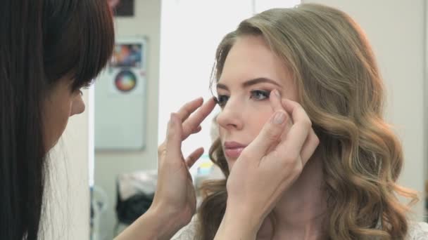 Maquillaje artista pega las pestañas a la chica — Vídeos de Stock